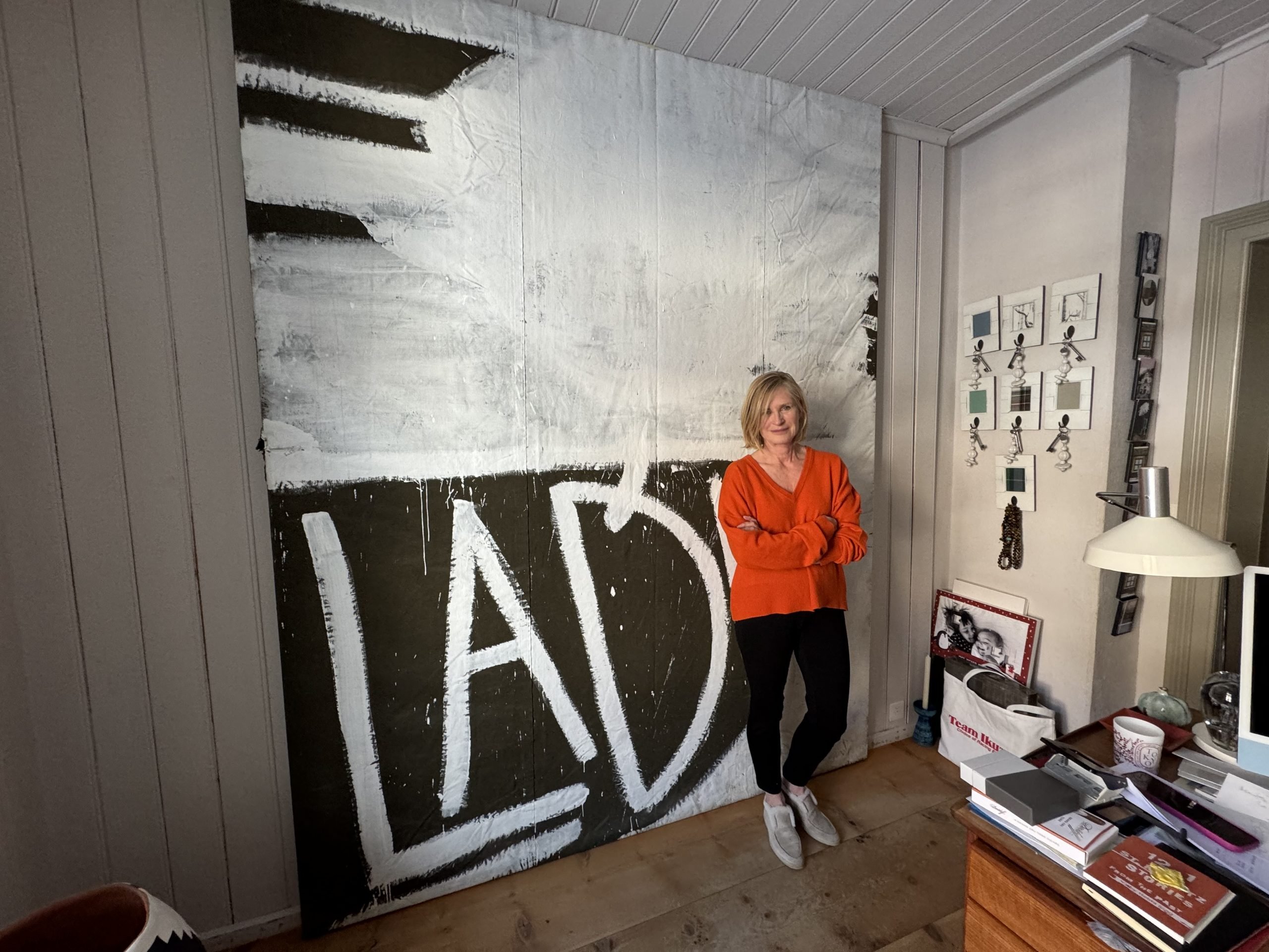 A woman stands in front of an enormous painting