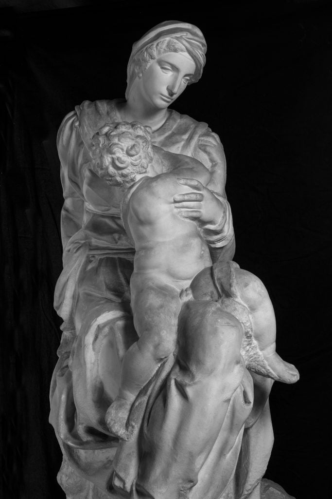 a classical style statue of a woman holding a baby