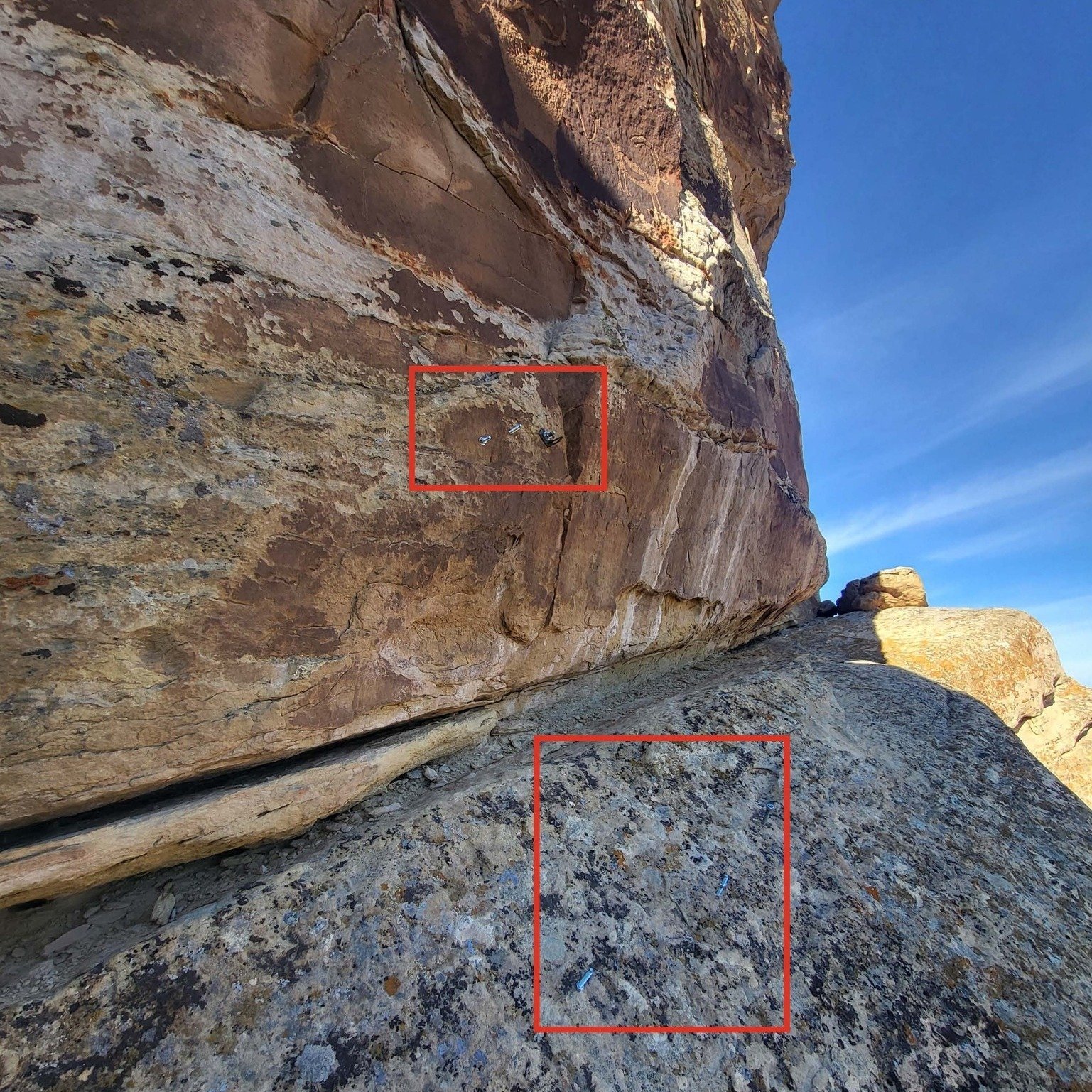 A red bounding box inserted into an image highlights the location of the climbing bolts near ancient petroglyphs