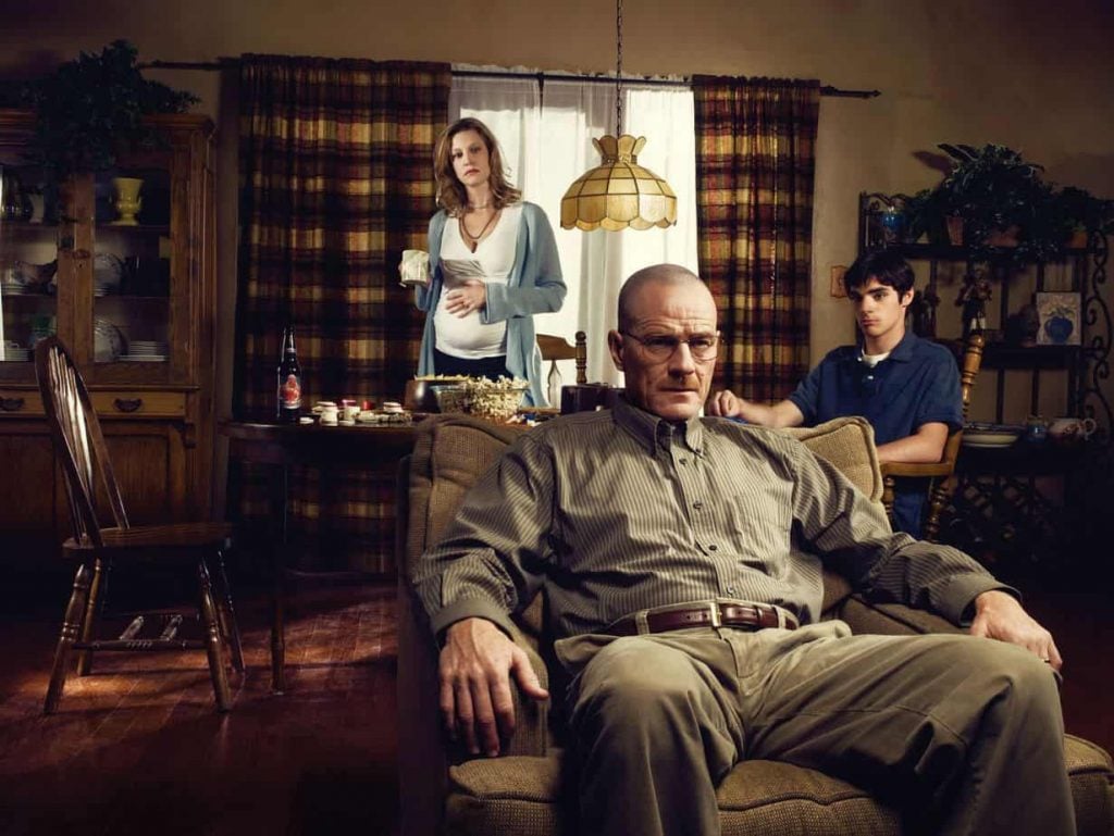 Breaking Bad cast photo: Walter White sits in a chair, flanked by Skyler and Walter Jr., with a tense atmosphere