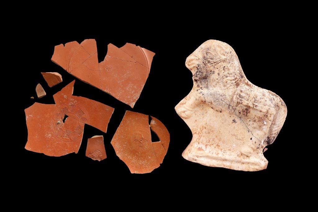 Ancient pottery shards and a small statuette depicted against a black background