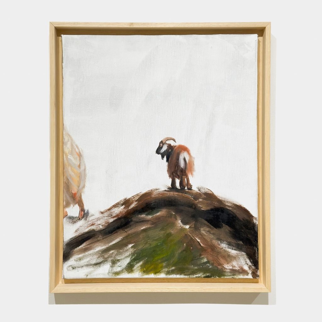 A solitary goat perched atop a hill against a stark white background, evoking isolation.