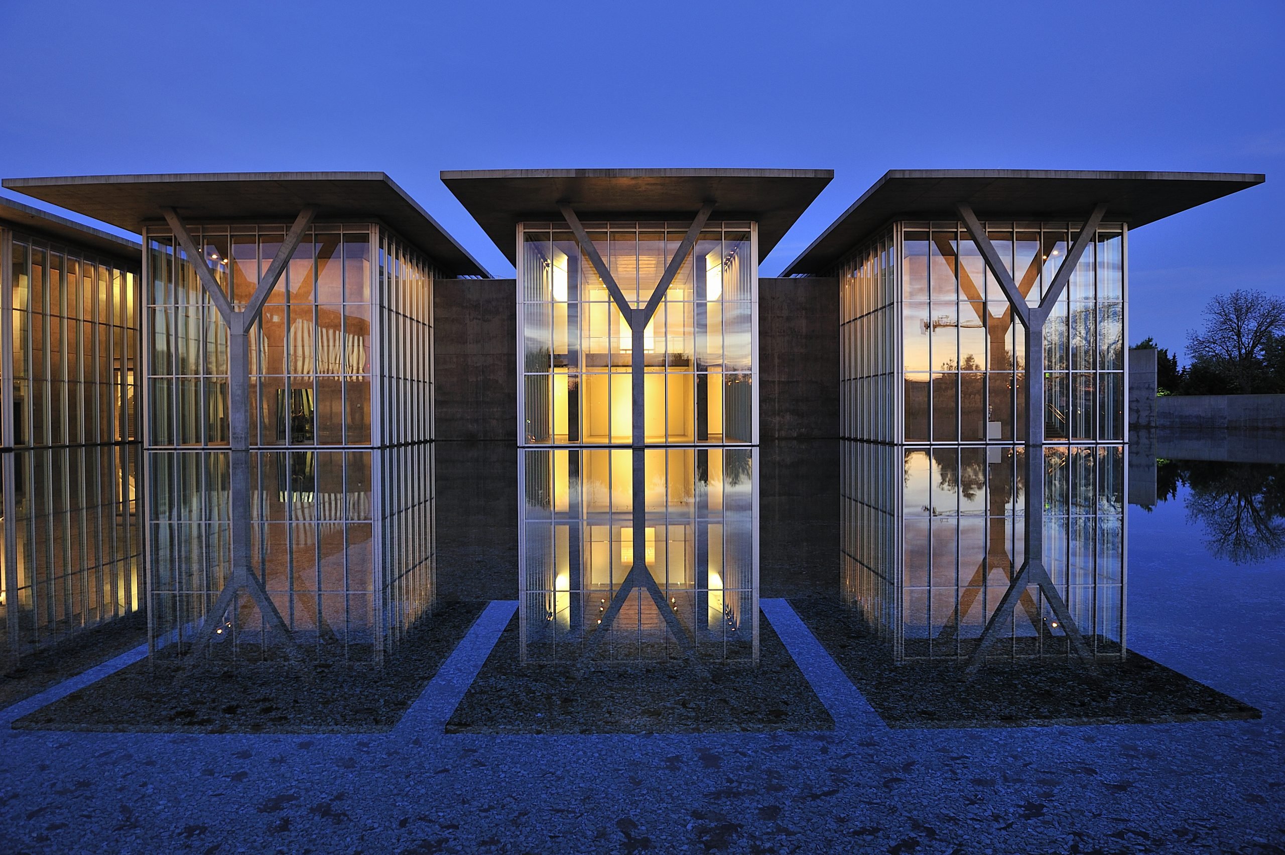 Modern Art Museum of Fort Worth illuminated at night, reflecting on a tranquil water surface