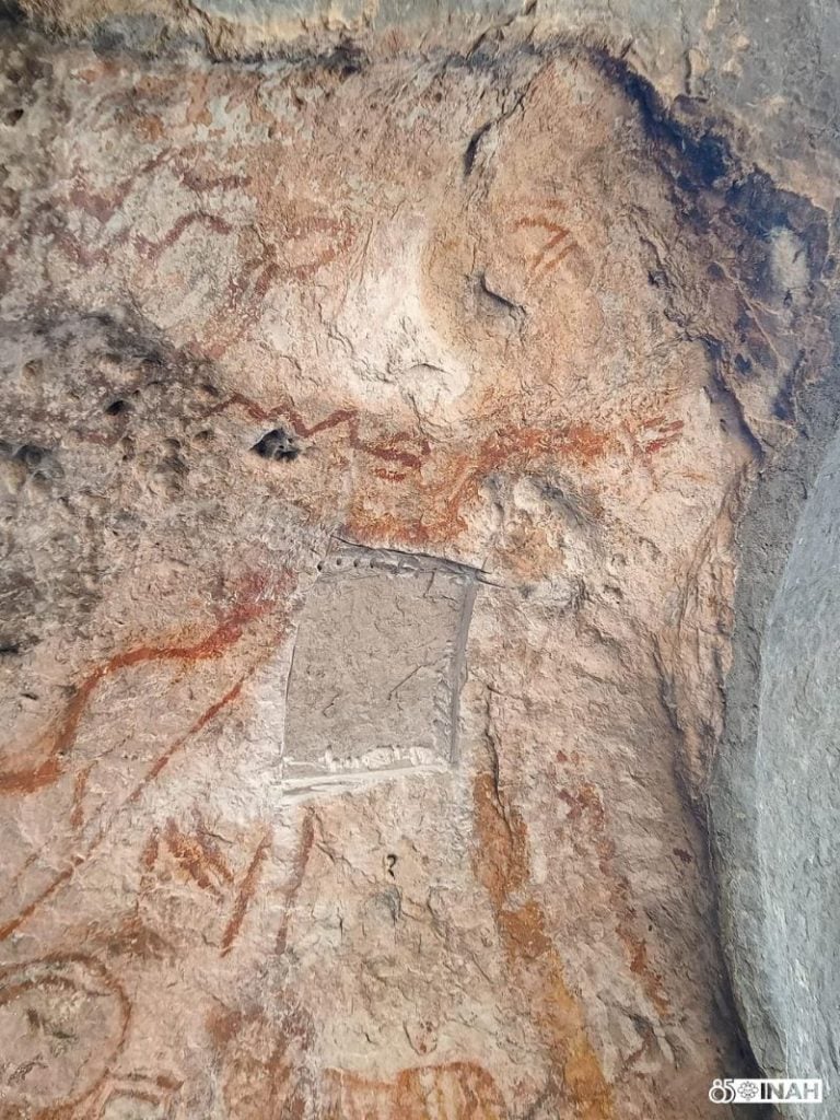 Damage to the cave wall where a panel of ancient art sits is pictured