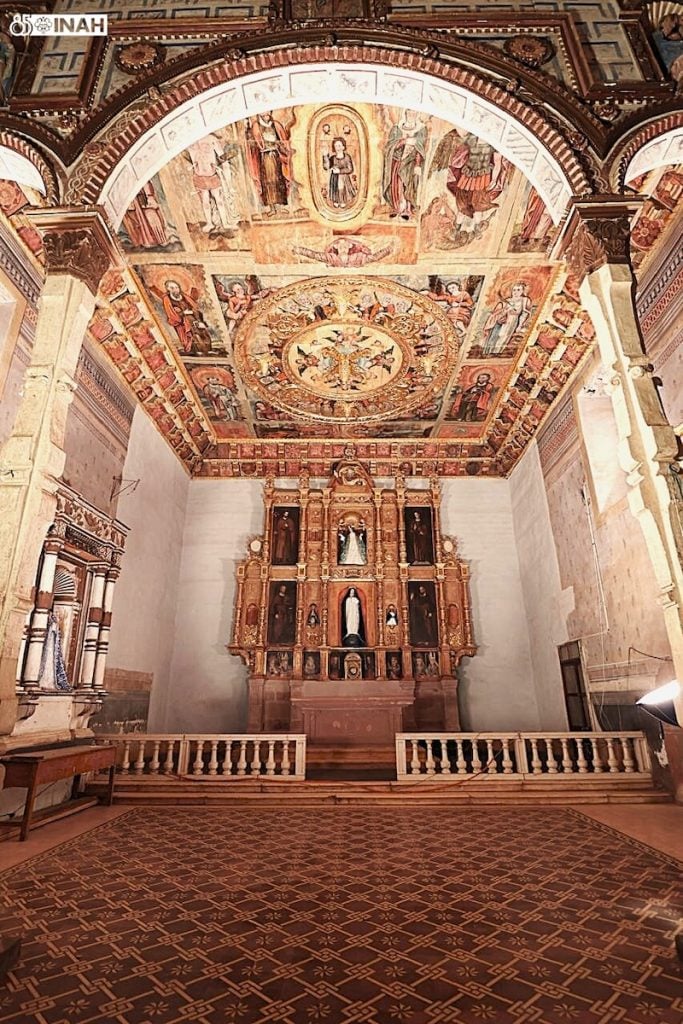 Interior of the Lady of the Assumption church, showcasing intricate frescoed ceiling and golden altarpiece.