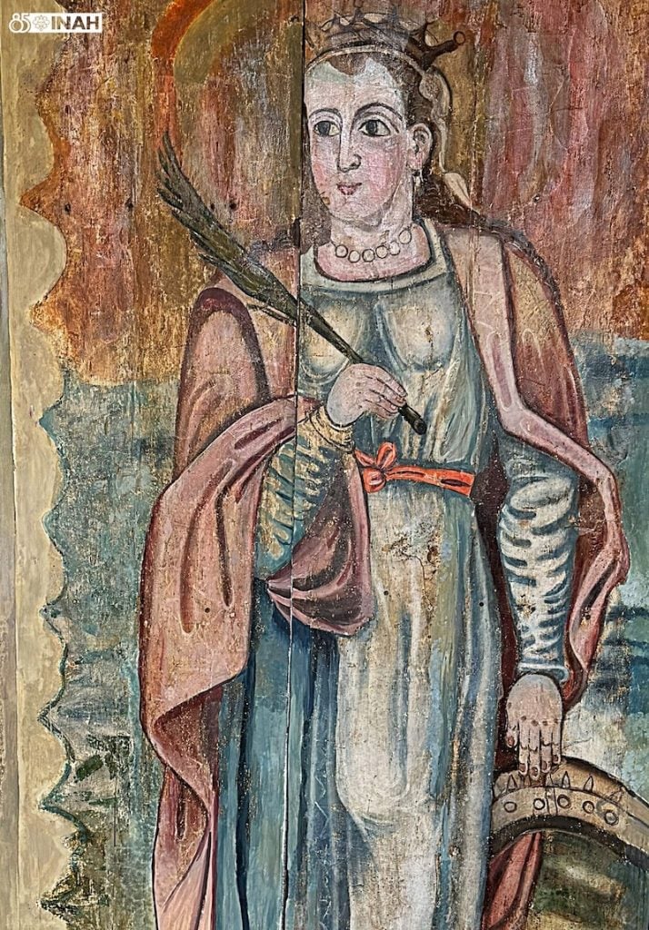 Fresco of a crowned female saint holding an arrow, painted with vibrant and naturalistic tones.