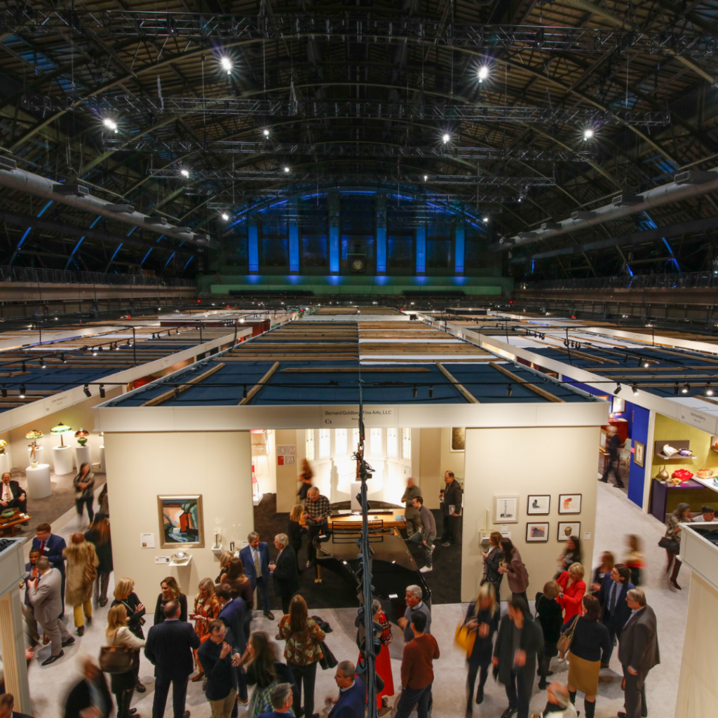 An overview shot inside the Park Avenue Armory showing the tops of dozens of exhibitor booths at the Winter Show.