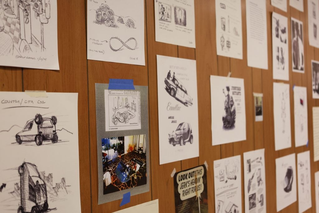 A wall taped with drawings of inventions