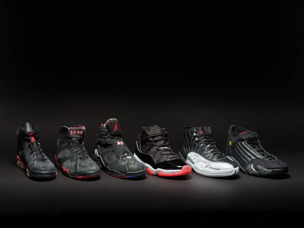a row of nike sneakers against a black wall
