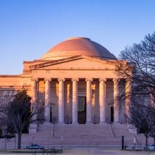 The neoclassical West Building of the National Gallery of Art in Washington, D.C., at sunset.