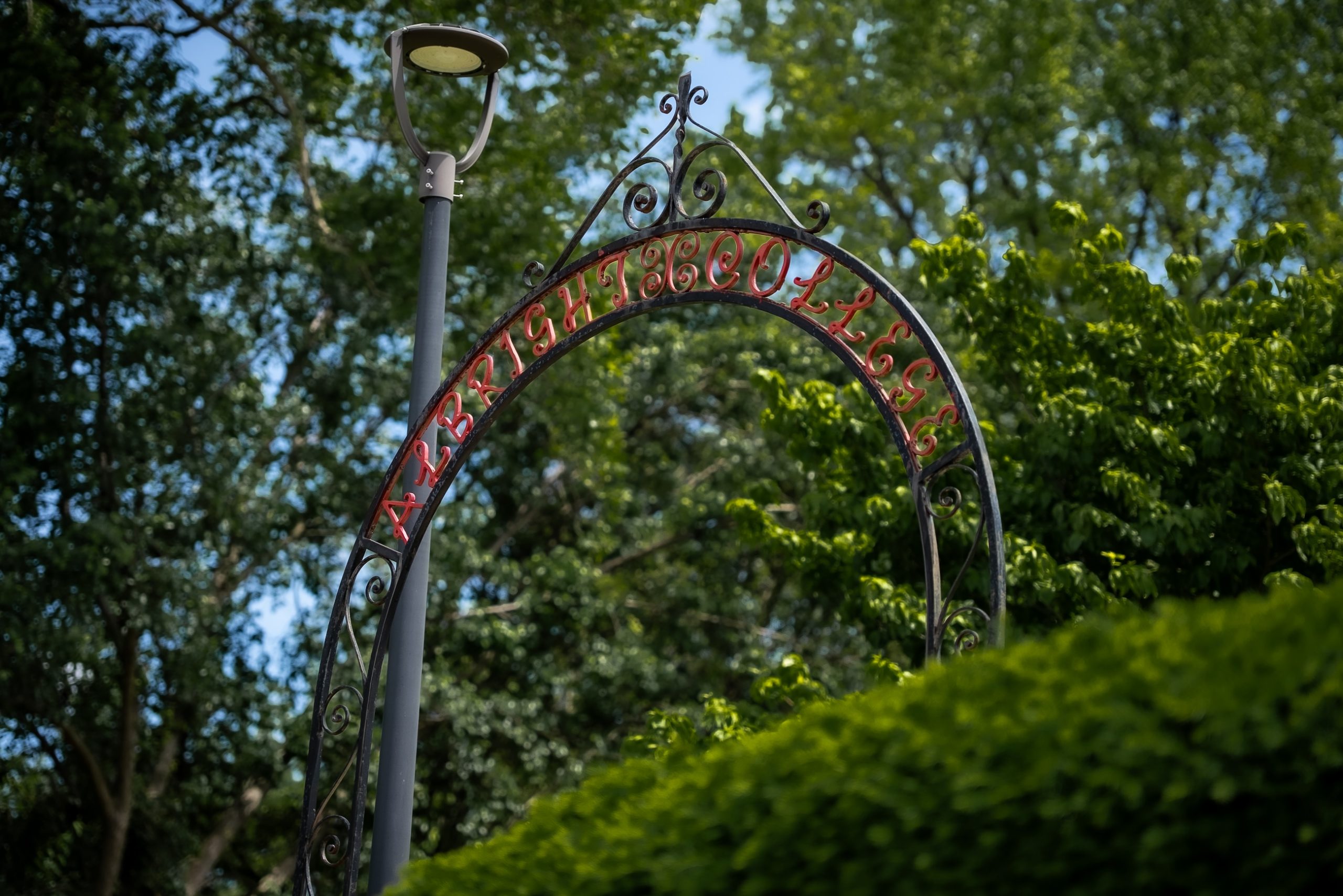 A photo of a leafy campus shows a gate decorated with the words Albright College