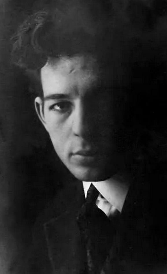 a black and white photograph of a young white man with dark hair and wearing a suit and tie who drew the cover of Great Gatsby