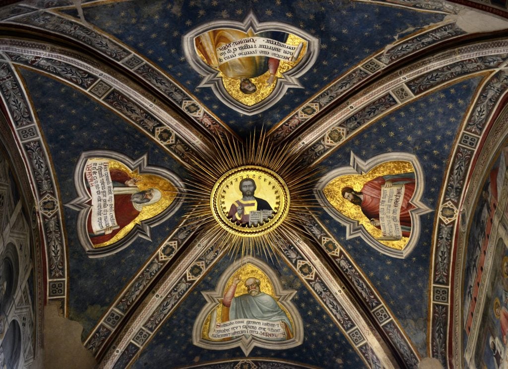 Painted ceiling of the Rinuccini Chapel in Santa Croce, Florence, with central Christ medallion surrounded by prophets on a starry blue background.