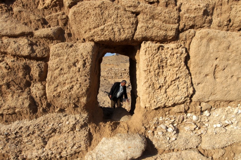 A man framed through a stone doorway in an ancient wall at Anthedon Harbor, considered Gaza’s oldest harbor with archaeological significance.