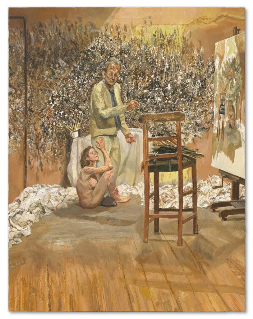 A painting shows the artist Lucian Freud standing in his studio near a painting on an easel, with a seated naked woman clutching his leg, all in front of a wall smeared with paint A painting shows the artist Lucian Freud standing in his studio near a painting on an easel, with a seated naked woman clutching his leg, all in front of a wall smeared with paint