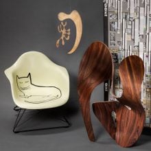 a chair with a cat drawing a mobile and a sculpture presented for a photograph