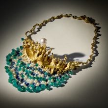 A surrealist necklace in gold and shades of blue and green