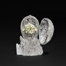 The opened Fabergé Winter Egg revealing a delicate basket of white enamel flowers inside its crystal shell.