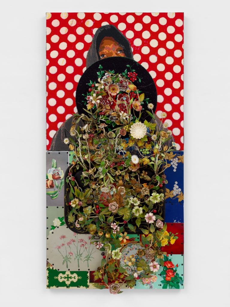 A richly textured piece featuring a hooded figure partially obscured by an explosion of flowers and found objects against a bold red polka-dot background.
