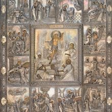 A Russian Orthodox icon with a silver oklad cover, intricately decorated with embossed and engraved religious scenes. The central panel depicts the Resurrection of Christ, surrounded by twelve smaller border scenes illustrating church feasts. The figures and details are highlighted with gilding, emphasizing halos, garments, and architectural elements. The ornate frame features geometric and floral motifs.