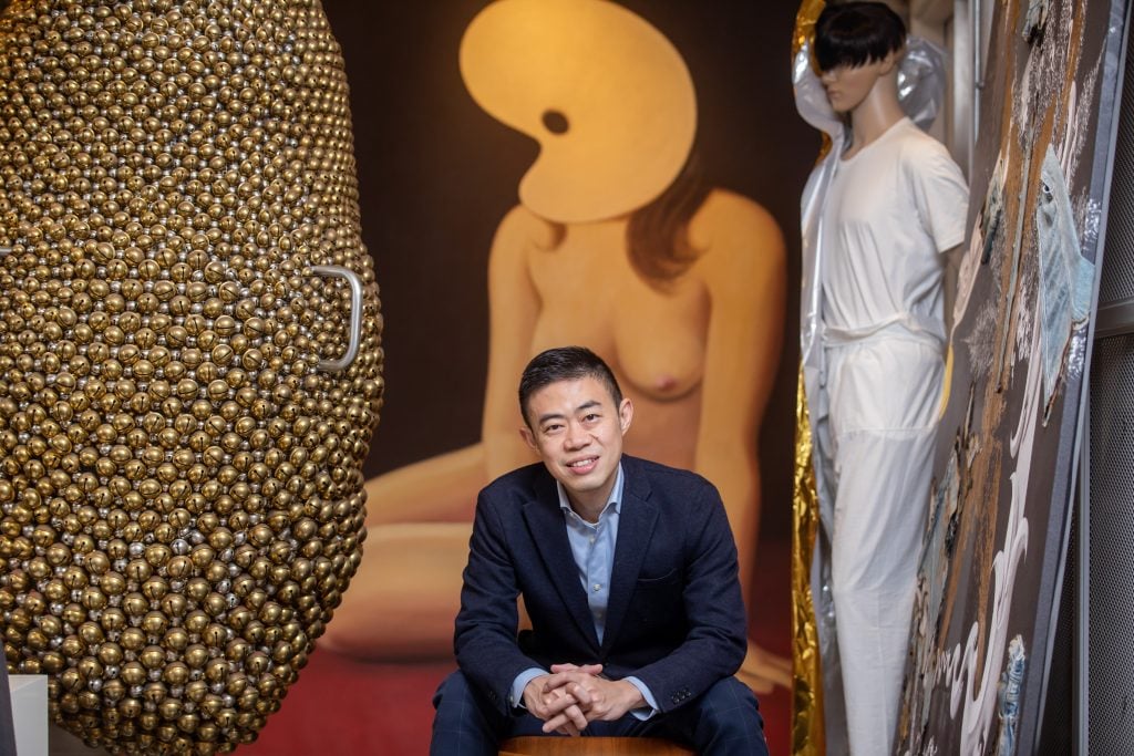 Collector Alan Lau poses in front of Wang Xingwei’s Untitled (Palette) (2013) and, at left, Haegue Yang’s Sonic Dance, Twin Sister (2014) at his studio in Hong Kong. Photo: Paul Yeung.