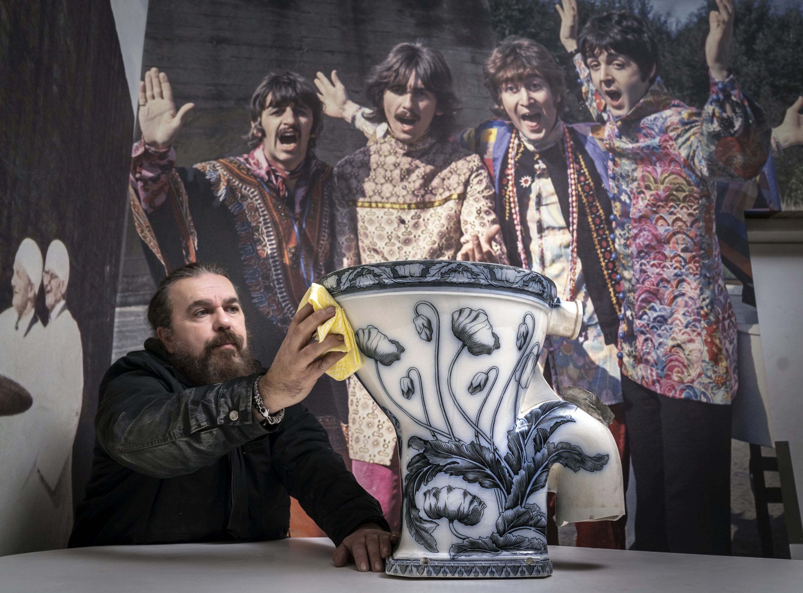 Roag Best gives a final polish to John Lennon's toilet, ahead of the item going on display at the Liverpool Beatles Museum. Photo by Danny Lawson/PA Images via Getty Images.