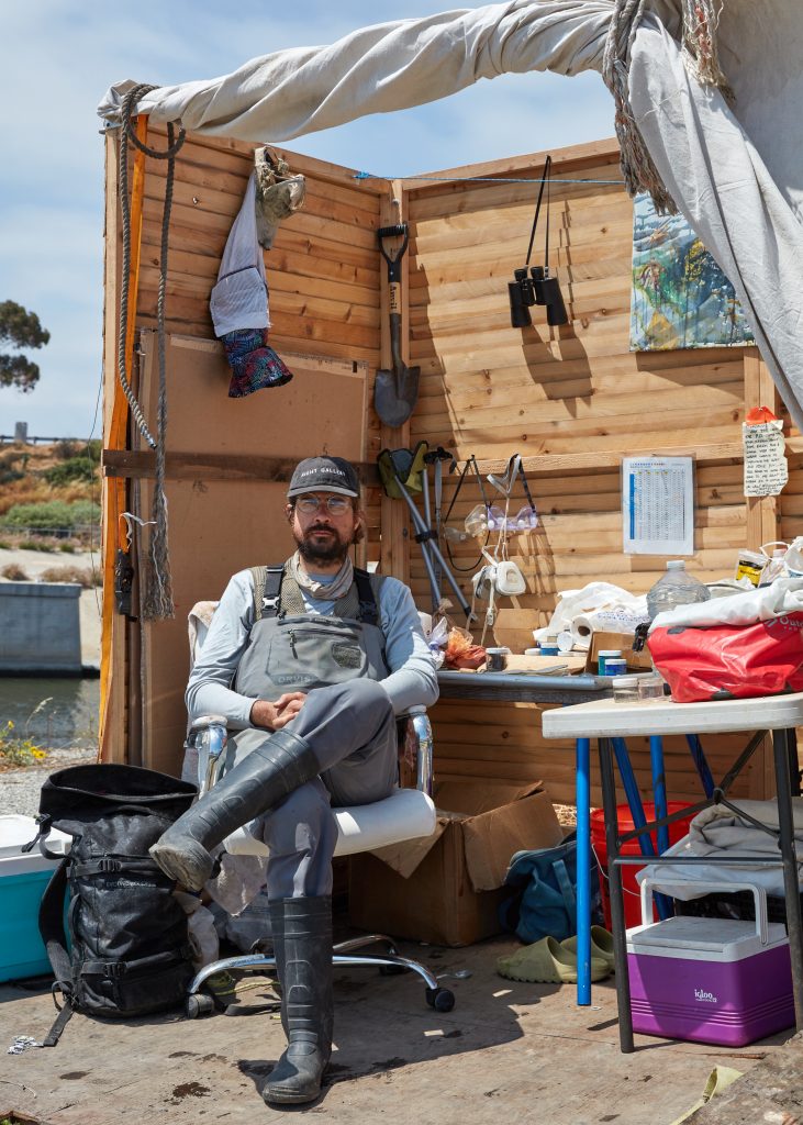 Sterling Wells working on his raft in Ballona Creek, Los Angeles. Photo by Nik Massey, courtesy of Night Gallery, Los Angeles.
