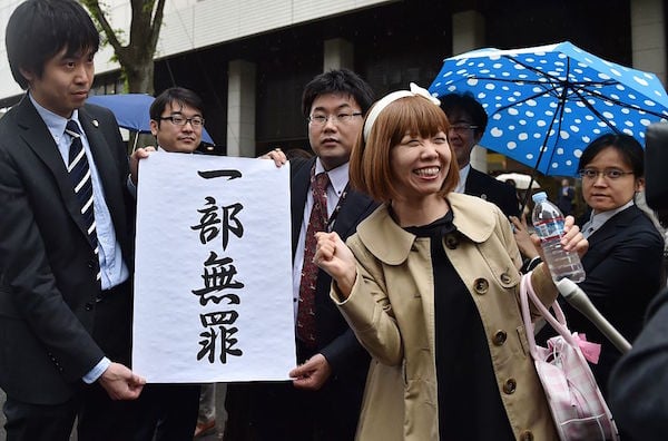 Megumi Igarashi and her lawyers pose with a sign reading “a part is not guilty" in front of the Tokyo District Court on May 9, 2016. Photo: KAZUHIRO NOGI/AFP/Getty Images.